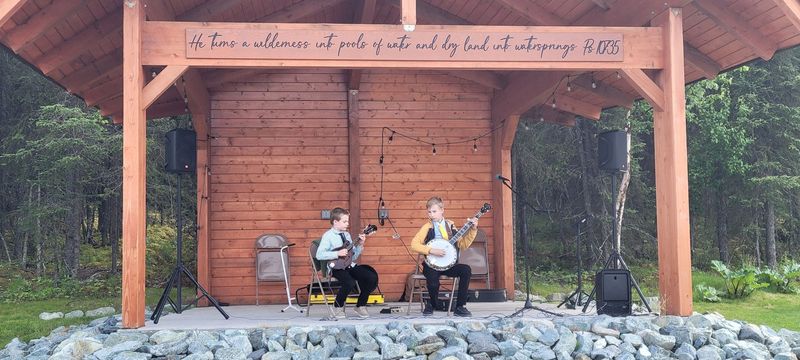 Two musicians performing on the covered timber stage