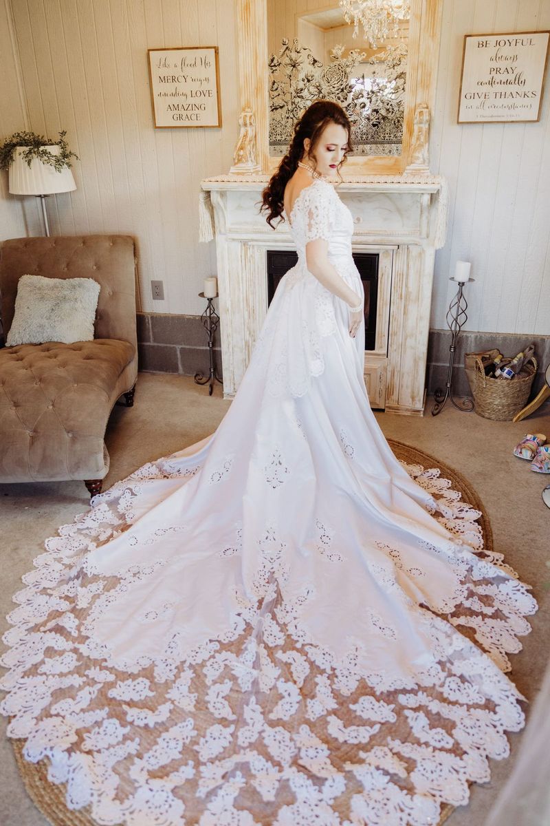 A bride in the bridal suite with a long lace train