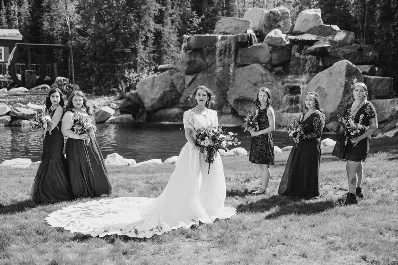Black-and-white photo of a bride and her bridesmaids beside the waterfall