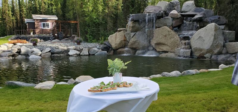 A table with appetizers set beside the pond