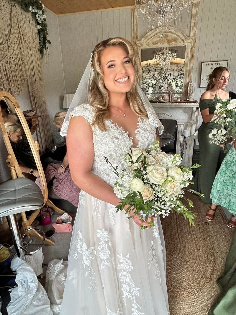 A smiling bride holding her bouquet in the bridal suite