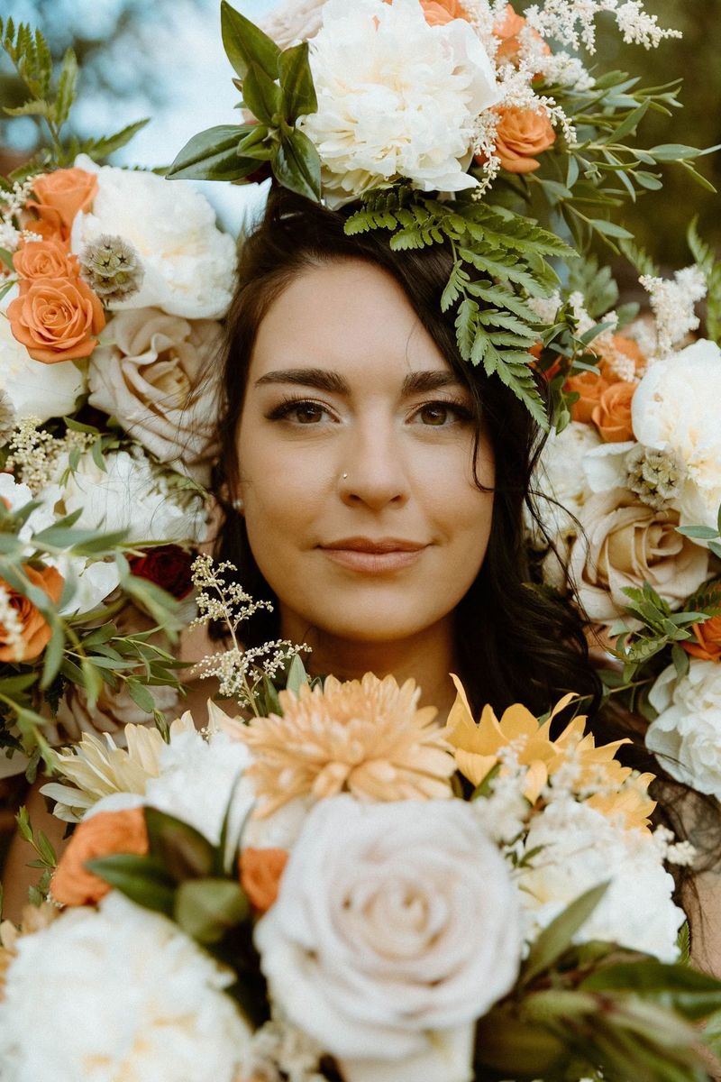 A woman framed by peach and white roses
