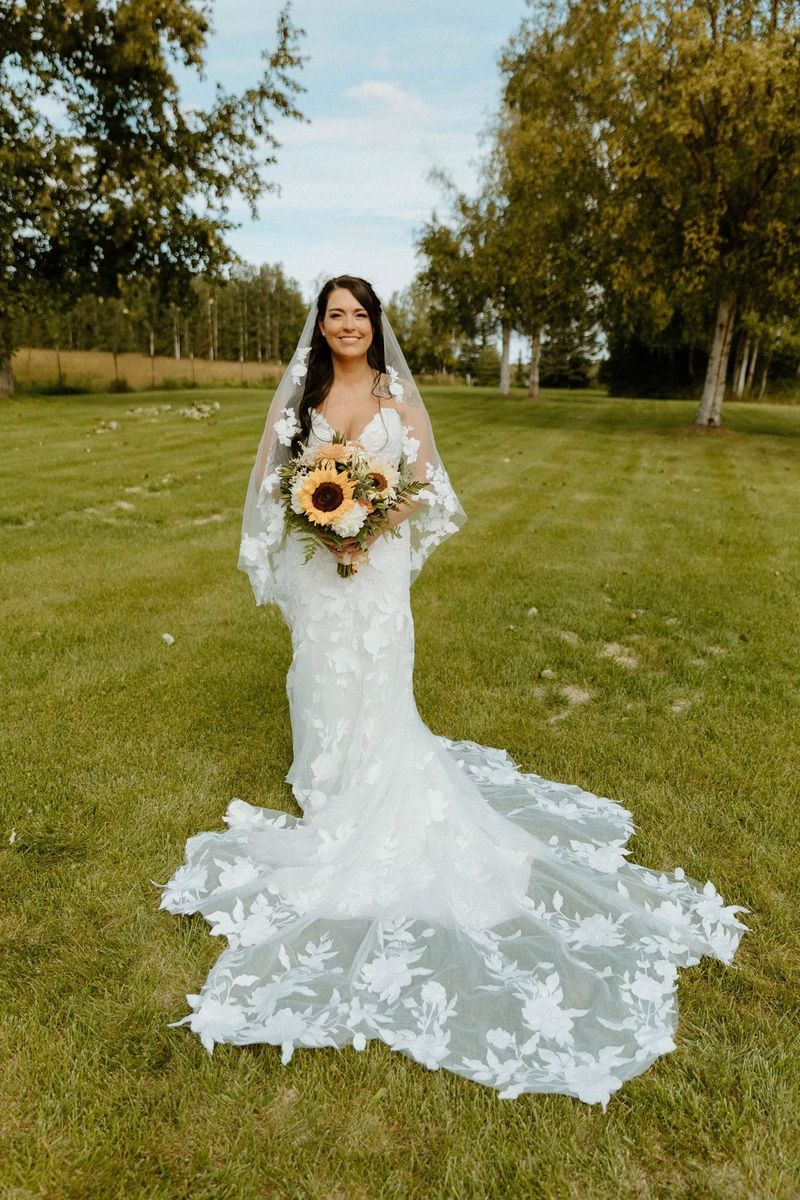 A bride holding a sunflower bouquet on the lawn
