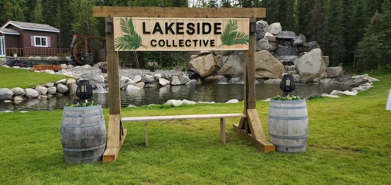 A Lakeside Collective sign between two barrels by the pond