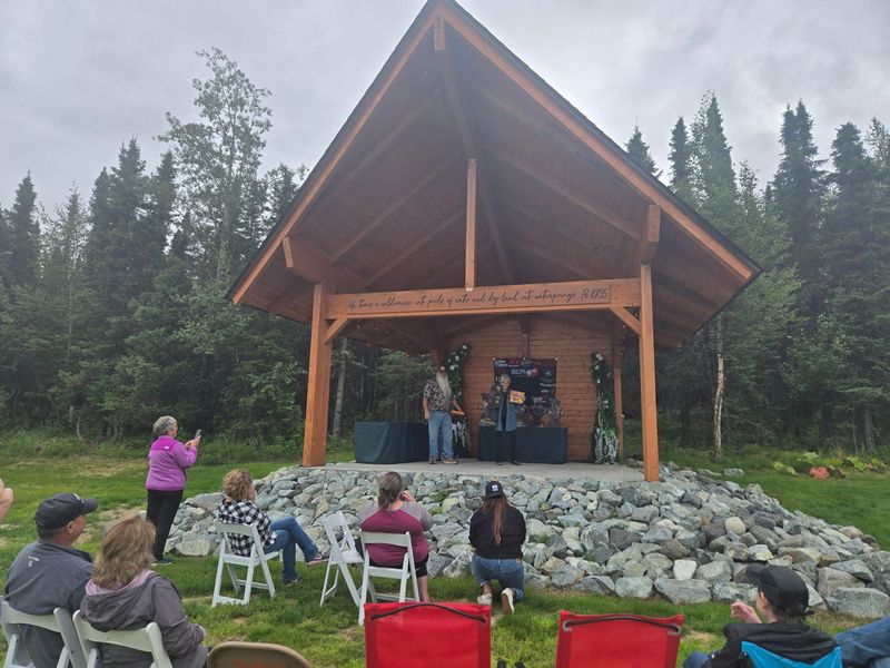 Guests seated on the lawn watching a performance on the outdoor stage